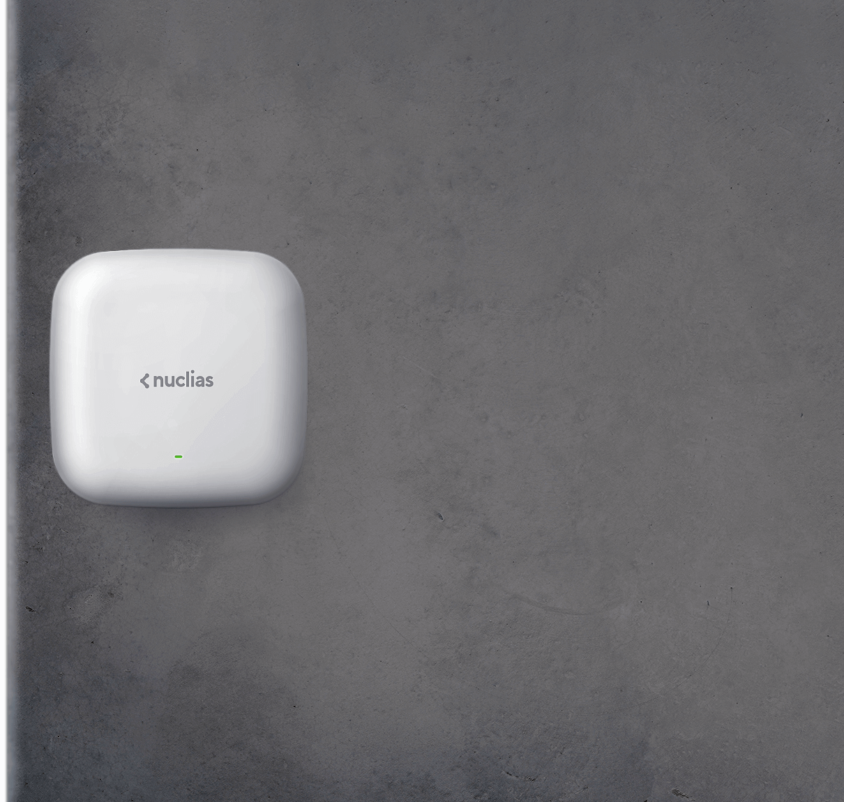 Nuclias Connect access point mounted to a grey office wall.